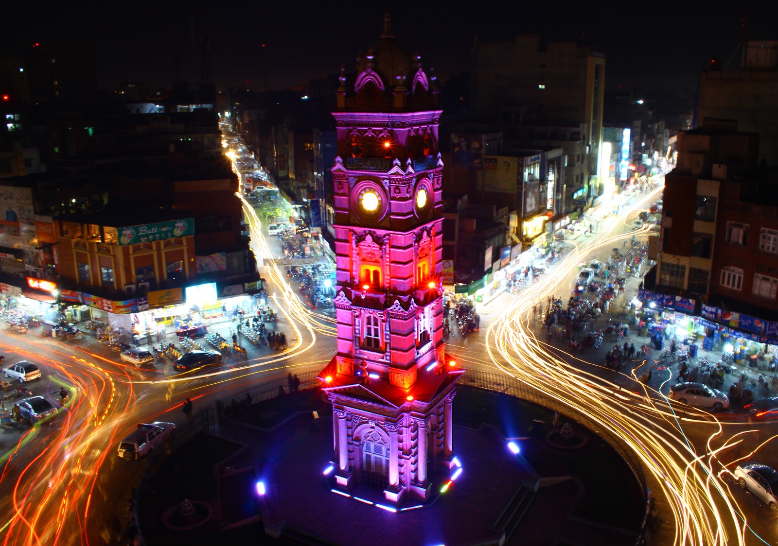 The historic Clock Tower of Faisalabad at night, surrounded by light trails